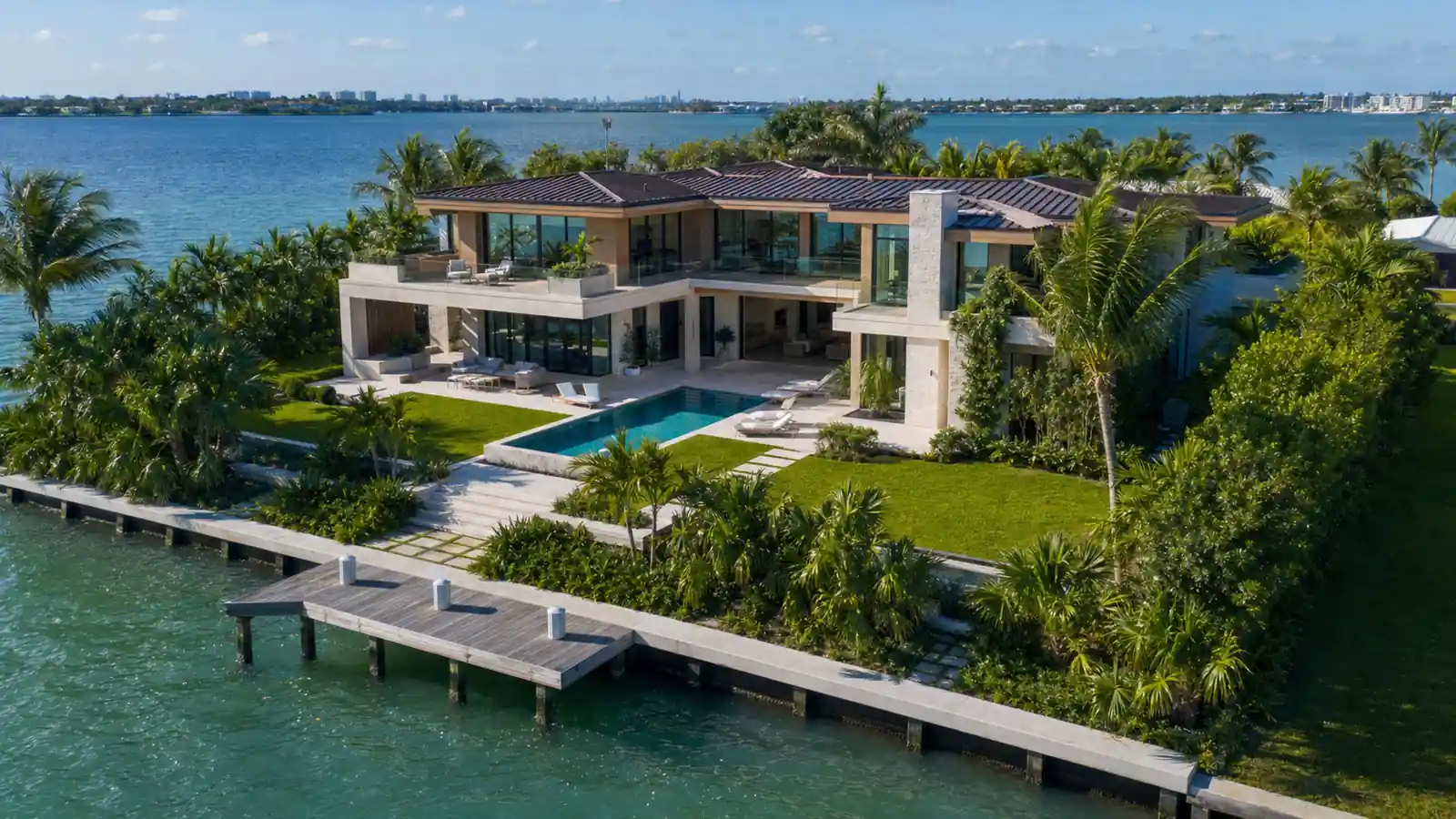 Aerial view of a modern waterfront estate with pool and private dock on Biscayne Bay — luxury waterfront estates Miami